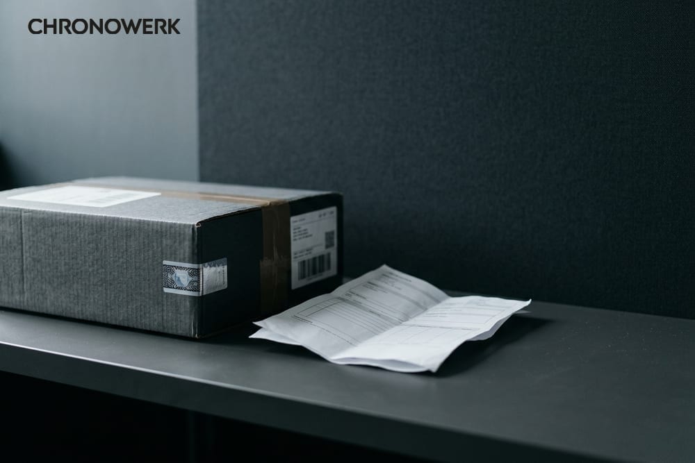 Makro eines Sicherheits-Siegelbandes auf gebürsteter Stahl-Oberfläche — Header für CHRONOWERK Versand-Sicherheits-Artikel