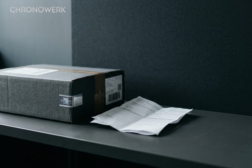 Makro eines Sicherheits-Siegelbandes auf gebürsteter Stahl-Oberfläche — Header für CHRONOWERK Versand-Sicherheits-Artikel