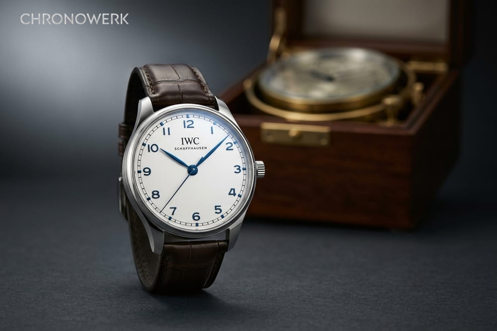 Marine-Chronometer in offener Kardanbox neben Seekarte und Zirkel auf dunklem Tisch — Header zur Portugieser-Geschichte