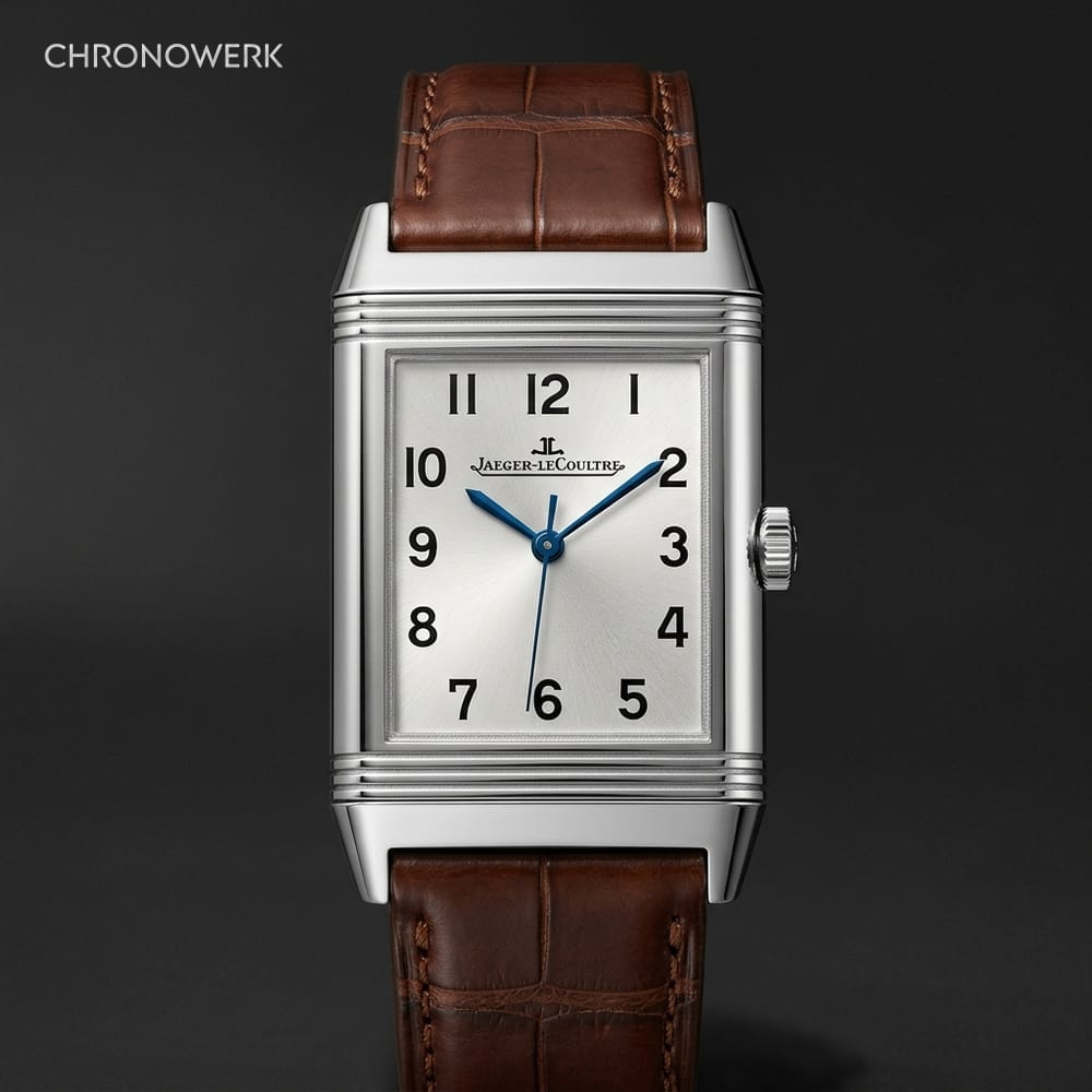 Rechteckige Uhr mit wendbarem Gehäuse neben freigelegtem Uhrwerk auf Anthrazit-Bühne — Marken-Guide Jaeger-LeCoultre im CHRONOWERK Blog